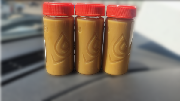 Three bottles showing lube oil contaminated with water — milky emulsion instead of clear amber